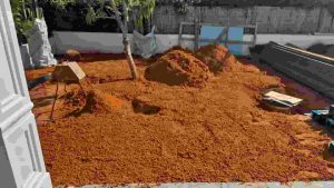 “שביל בגינה עם אדמת חמרה טבעית, משתלב עם צמחייה ירוקה ליצירת מראה אותנטי ושקט ויזואלית.”